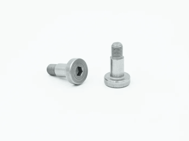 When an assembly fails due to an improper fastener, the cost is no longer just replacing a component. Time is lost, work needs to be redone, and in some cases, a component can be scrapped, which could have taken hours to machine. Anyone who works in a high-tolerance environment understands this feeling. One bad decision in the fastener selection process can cause a project to be stalled for days. Shoulder screws do not always get the attention they deserve in that conversation. They should. Here is why they matter more than most people think. What Makes a Shoulder Screw Different A shoulder screw has three distinct sections: a head, a smooth cylindrical shoulder, and a threaded end. The shoulder is the key part. It is precision-ground to a tight dimensional tolerance, usually within 0.001 inches or better. That smooth, unthreaded section is what separates it from a standard fastener. Standard screws grip by threading into a material. Shoulder screws work differently. The shoulder acts as a bearing surface, a pivot point, or a precise spacer. The threaded portion only anchors it in place. The shoulder does the actual mechanical work. This distinction matters a lot in assemblies where movement, alignment, or spacing needs to be exact. Where Shoulder Screws Get Used The list of applications is longer than most people expect. Pivot points in jigs and fixtures Linear guides and slide mechanisms Cam followers and linkage assemblies Precision spacing in multi-layer assemblies Hinges in aerospace and defence components Robotic arm joints and actuator mounts What connects these applications is the need for controlled movement or precise positioning. A shoulder screw does not just hold things together. It defines how those things relate to each other spatially. In a jig or fixture, even a 0.01mm shift in a pivot point can throw off the entire operation. A shoulder screw, properly specified, keeps that shift from happening. The Real Risk of Getting It Wrong A lot of engineers substitute a standard bolt with a washer when they need a shoulder screw function. It works, sometimes. But it rarely works consistently. The problem is tolerance stacking. A bolt and washer combination introduces multiple surfaces, each with its own dimensional variation. Over time, and under load, those variations add up. What starts as a minor slip becomes a measurable error. In precision assemblies, that error is the difference between a part that passes inspection and one that does not. There is also wear to think about. A smooth, hardened shoulder resists wear far better than the body of a standard bolt. In pivot applications, this matters. A worn pivot changes the geometry of the assembly. That changes the output. And in industries such as aerospace or medical device assembly, changes in output are not acceptable. The fear is legitimate. Design something precise, specify the wrong fastener, and your tolerances will be gone in a few thousand cycles. Material and Hardness Matter Shoulder screws have several materials from which they're manufactured: Stainless Steel, Alloy Steel, and, in weight-constrained systems, Titanium. Material selection is significant for both performance and environmental considerations. Alloy Steel shoulder screws, designed to either ASTM or DIN specifications, have high tensile strengths. They're good for high-load pivot applications where the shoulder is subject to significant stress. Stainless Steel is good in corrosive environments, but is generally not as hard. That is significant if your assembly is in a wet or chemically active environment. The shoulder hardness is perhaps the most overlooked spec. A harder shoulder resists galling and wear in rotating or oscillating contact. Rockwell C hardness ratings for alloy steel shoulder screws typically range from 38 to 43 HRC, according to manufacturer data from Holo-Krome. If there are repeated movements, shoulder hardness is not optional information. It defines service life. Fit Tolerance and Why It Changes Everything Shoulder screw fit, or the relationship of the screw to the hole it fits into, is where precision either occurs or does not. There are three types of fit that are of concern: Clearance fit: The hole is somewhat larger than the shoulder screw. It allows for free rotation or sliding motion. Transition fit: Slight clearance or interference. It is used for alignment, but motion is necessary. Interference fit: The shoulder is larger than the hole. Used for fixed, non-moving applications. For most pivot and sliding applications, a clearance fit with tight tolerances, typically H7/h6 in ISO terms, gives the right balance of free movement and positional accuracy. The ISO 286 standard outlines these fit classifications in detail. Getting the fit wrong usually means one of two things: too much slop causes positional error, or too much interference creates binding and accelerated wear. To Conclude Shoulder screws are not complex fasteners. The complexity is in matching them correctly to what the application actually demands. Get that part right, and they will hold up for a long time.